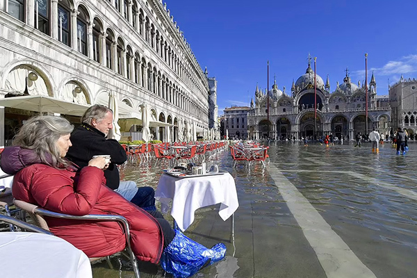 Du khách đi ủng, lội nước uống cà phê giữa 'thành phố lụt' Venice